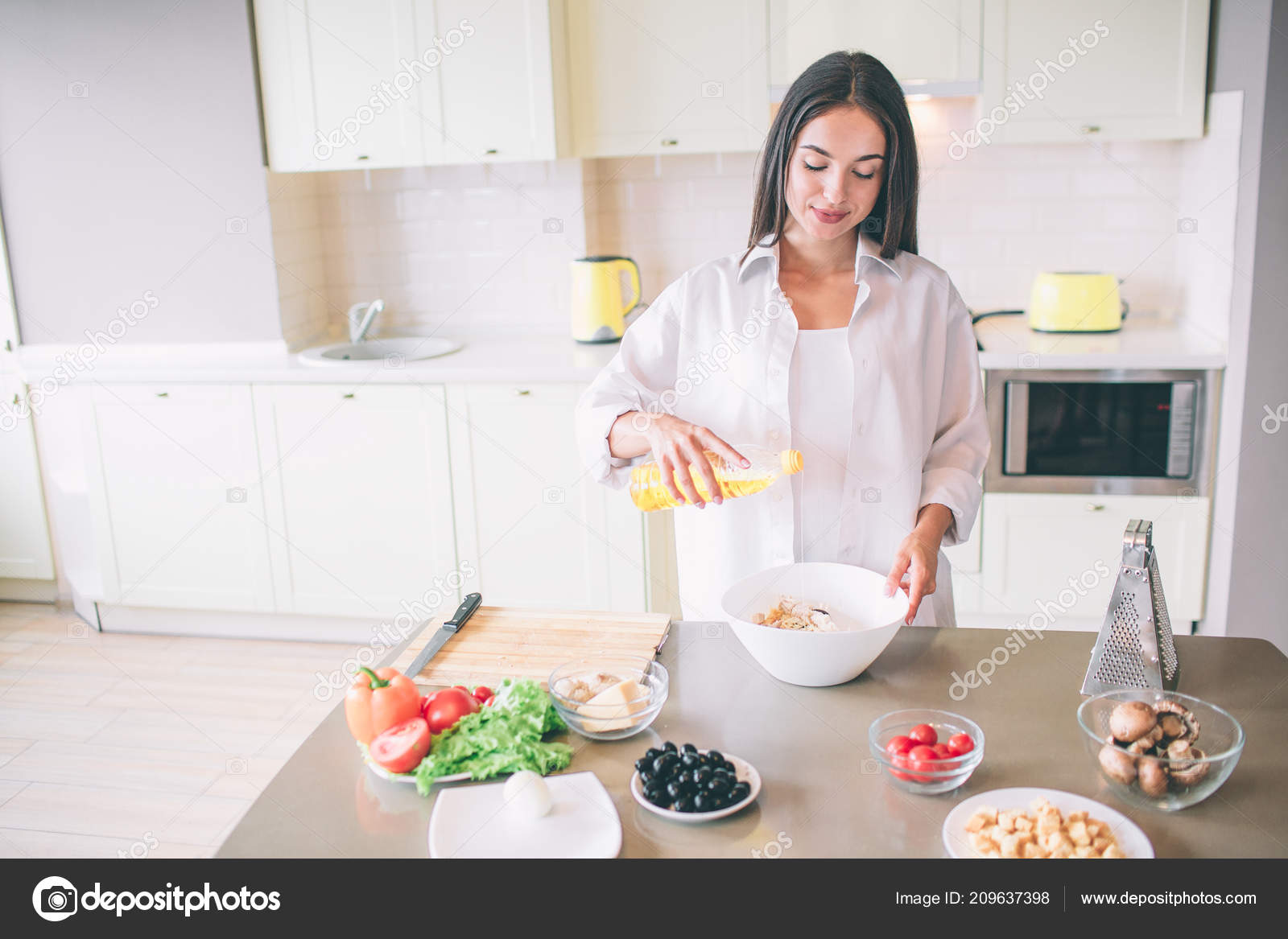 Nice Girl Is Cooking In Kitchen She Is Mixing Ingredients For Salad In Bowl Girl Is Calm And Concentrated Stock Photo Image By C Estradaanton