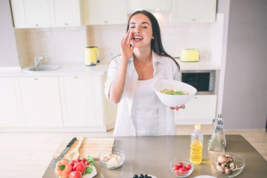 Mutlu kız arıyor. O tabak salatası elinde tutar. Var bolluk yemek kaldı gıda.