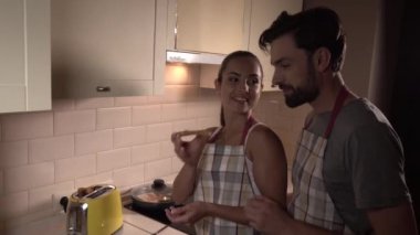 Kız adamla duruyor. O tost nutella ile üzerinde tutar. O zaman kız bu adama veriyor. O parça ısırıkları ve çiğnemeyi başlar. O gözü üstünde ve gülümseyerek. Kız bir parça kızarmış ekmek de ısırıkları.