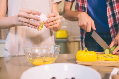 Kesme görünümünü adet masa içine salatalık kesme eller mans. Kız sonları yumurta ve poure içine cam kase. Birlikte çalıştıklarını.
