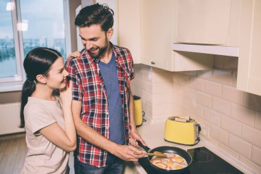 Güzel insanlar birbirlerine ve gülümseme bak. Kız adam duruyor ve ona eğilir. Gıda tavada kızartma.