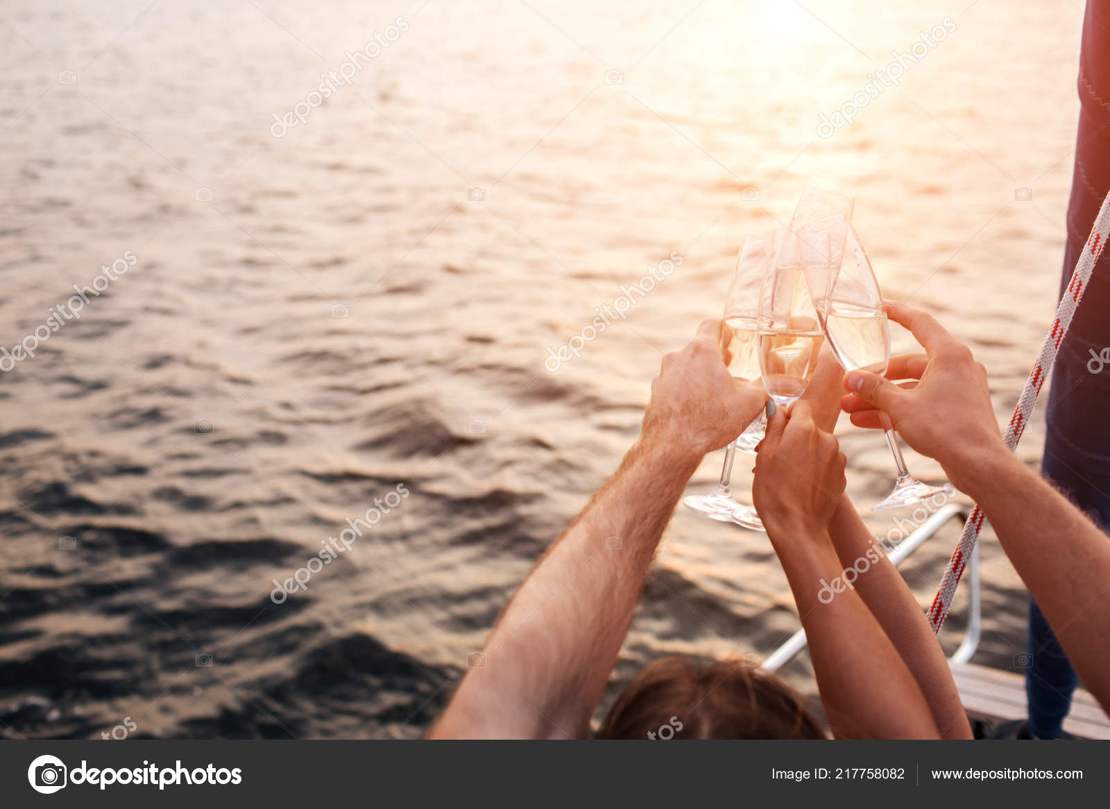 Nice Picture Of Four Hands Holding Glasses Of Champaigne In Front Of Water They Have Some Rest