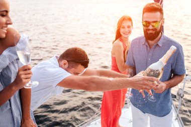 Chmpaigne önünde kendini şişe tutan adam komik resmi. Herkes gözlük tutuyor. Onlar gülüyor. Öndeki adam güneş gözlüğü takıyor.