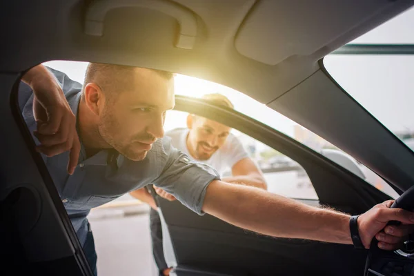 Duas pessoas estão sentadas juntas no carro e olhando no tablet que a  garota está segurando. eles estão olhando para a tela com interesse e  emoção.