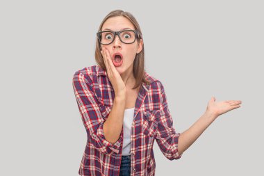 Şaşırdım ve heyecanlı genç modeli açılan geniş ağızlı kamerada görünüyor. O tek eliyle sağ başka bir yanak ve puan sahiptir. Gri arka plan üzerinde izole.