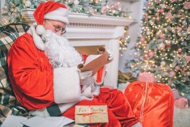 Ciddi ve düşünceli bir adam Noel Suite oturur ve mektupları okur. Diğer onun dışında masada vardır. Şömine ve Noel ağacı adam oturur.