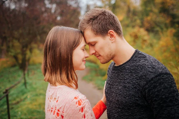 Bild eines jungen Mannes und eines verliebten Mannes. Sie halten die Köpfe eng aneinander. , lächelt sie. Sie halten die Augen zu. Menschen sind im Park. — Stockfoto