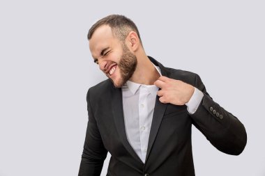 Takım elbiseli Genç adam acı. Yaka kenarından tutar ve çekin. Genç psikologlar adam. Beyaz arka plan üzerinde izole.