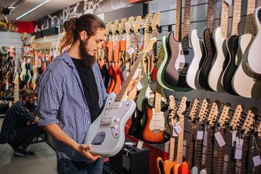 Genç müzisyen tutun açık mavi elektro gitar elinde sakallı. O baktığı.