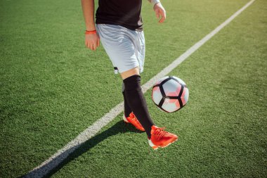 Oyun kesme görünümü bir adam. O bir ayak ile top başladı. Adam oyun futbol çimenlikte tek başına.