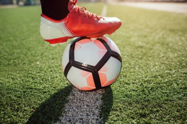 Futbol oyuncu ayak socker spor ayakkabı içinde kapatın. O topa tutan. Top geçerli çimenlerin üzerine boyalı beyaz çizgi üzerinde.