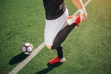 Bacak kadar ısınma futbolcu resmi. O lastik gibi. Adam ayakta beyaz çizgi, yeşil çim üzerinde. Top olduğunu.