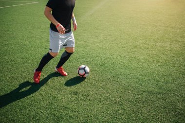 Futbol dışında yalnız oynayan adam görünümünü kesti. O topa tekme gidiyor.