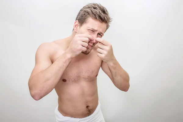 Adulto bonito cara apertar espinhas no nariz. O tipo tem acne. Ele está sozinho e sem camisa. Isolado sobre fundo branco . — Fotografia de Stock