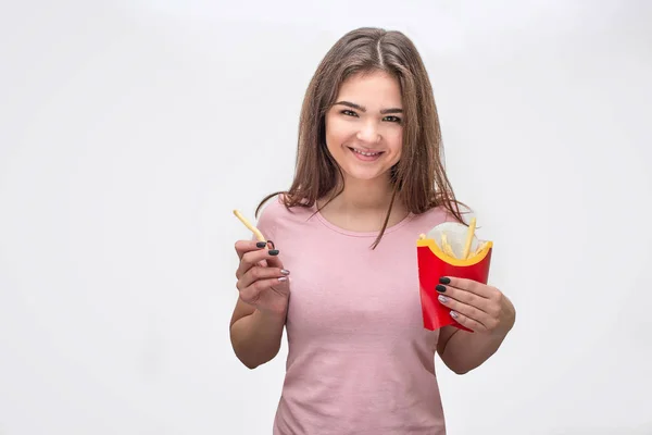 Gelukkige en vrolijke jonge vrouw blik op de camera en glimlach. Ze houden papier met gebakken aardappel. Geïsoleerd op witte achtergrond. — Stockfoto