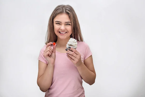 Glad ung kvinna titt på kameran och leende. Hon håller röd gelé sött och tårta. Isolerad på vit bakgrund. — Stockfoto