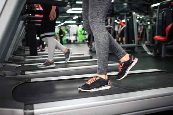 Snížení zobrazení yougn Dámské nohy chůzi na Běžecká stopa v tělocvičně. — Stock fotografie