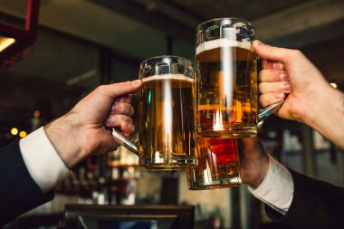 Erkekler elinde bira üç kupaları resmi. İnsanların takım elbise giymek. İçinde bulundukları bar.
