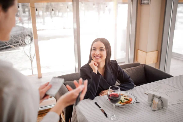 Vrolijke Jonge Zakenvrouw Zitten Aan Tafel Kijken Naar Serveerster Glimlachen — Stockfoto