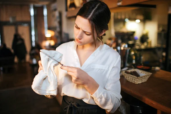 Meşgul genç garson standında bar ve bıçak silin. Bunda ciddi görünüyor. Yougn restoranda iş kadın. — Stok fotoğraf