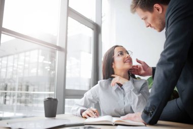 Neşeli genç kadın masada oturup patronuyla gülümse. Şuna bak. Adam cinsel heyecan duymaktadır. Onun yüzünü dokunduğu