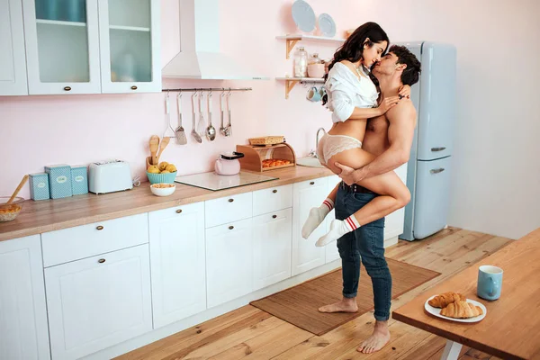 Seksi genç çift itchen içinde. O onu elinle tutun. Modeli embrace adam. Öpüşüyorlar.