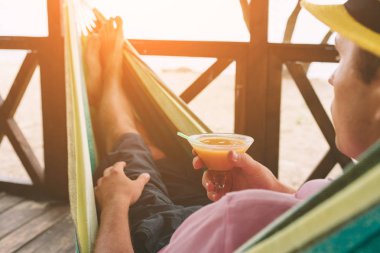 Okyanus tarafından sunny Beach Hamakta yatan genç adam.
