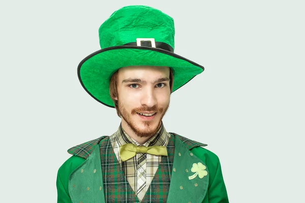 Joven pelirrojo en traje de santo verde Patricks y sombrero se ven directamente en la cámara. Aislado sobre fondo blanco . — Foto de Stock