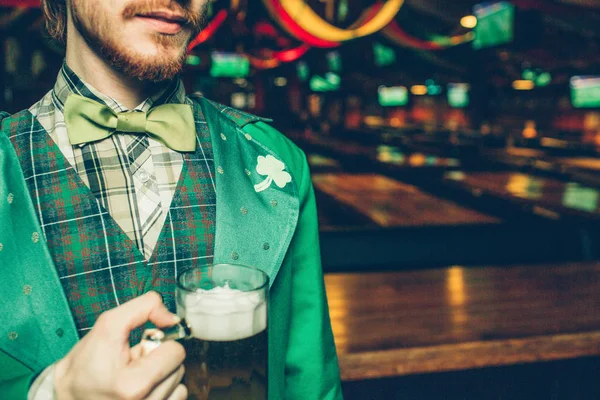잘라 보기 남자의 녹색 세인트 패 벌 서 술집에서 맥주의 얼굴을 누르고 있습니다. 남자는 방에 혼자. — 스톡 사진
