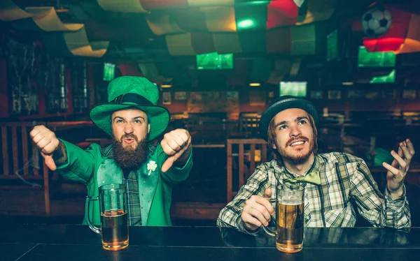 A férfiak nagyon ideges ypung mutat nagy hüvelykujj-le, és keresse fel. Ülnek a kocsmában inspirációk. Fickó St. Patricks megfeleljen bal kopás. — Stock Fotó