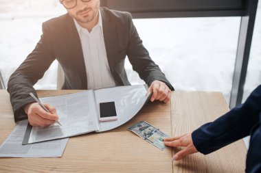 Kadın el dokunmak Oda tablo 100 dolarlık fatura. O adama vereceğim. Not defterinde yazmak ve paraya bak. Kesme görünümü.