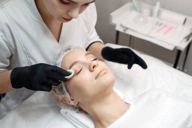 Şevval Özçelik Güzellik standı istemcileri kafa ve göz kapakları dikkatli temizlik cilt. Odada koltuk yatan genç kadın. Rahatla ve keyfini çıkar.