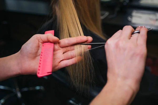 Zbliżenie: Fryzjer ręcznie cięcia blond włosy. Nowa fryzura robi w salonie piękności — Zdjęcie stockowe