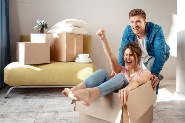 Genç aile çift satın veya kendi ilk küçük Daire Kiralık. Neşeli kadın çığlık kutusunda oturuyor. Adam onu taşımak. Taşınma sırasında oyun oynuyorlar.