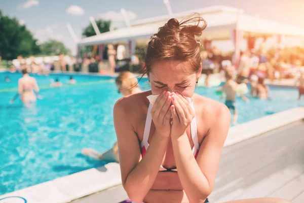 Picture from a Beautiful women in bikini with handkerchief. Sick female model has runny nose. girl makes a cure for the common cold. She is sick in the summer on vacation. — Stock Photo, Image