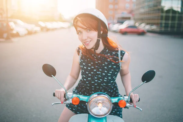 Χαρούμενο κορίτσι οδήγηση σκούτερ πόλης. Πορτρέτο του μια νεαρή και κομψή γυναίκα με ένα μοτοποδήλατο — Φωτογραφία Αρχείου