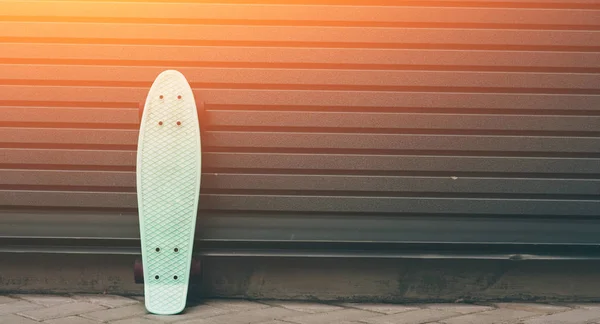 Ein an die Wand gelehntes Skateboard, rechts freie Fläche für individuellen Text — Stockfoto