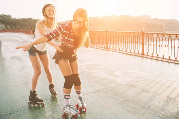 2 つのスリムでセクシーな若い女性とローラー スケート。1 人の女性はインライン スケート、他のクワッド スケート。太陽の光線に乗る女の子 — ストック写真
