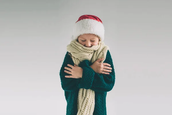 Menina em chapéu de Papai Noel isolado em branco. A criança l está vestida com suéter, boné de Natal e cachecol estúdio tiro — Fotografia de Stock