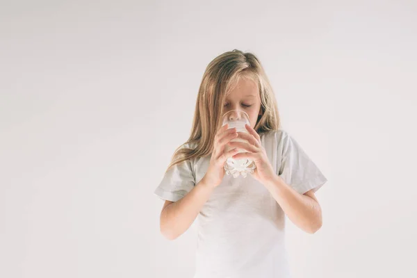 Girl is drinking fresh glass of milk isoladed on white background — Stock Photo, Image