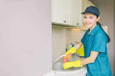 Olumlu ve güzel temiz lavabo standları ve kamera üzerinde görünüyor. O su tüp yıkar. Kız mutfakta toz ve durt Temizleme.