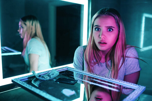 Drugs destroy you. Life or drug addiction. Shocked beautiful woman finds drugs in night clubs toilet. Surprise on the face of cocaine lines, banking card and banknote for sniffing on mirror surface