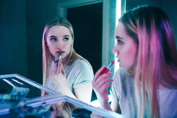 Non à la drogue. Portrait de jeune belle femme appliquant ses lèvres avec du rouge à lèvres près des lignes de cocaïne dans les toilettes des boîtes de nuit. Elle regarde le miroir. Mode de vie sain ou ajout de drogues — Photo