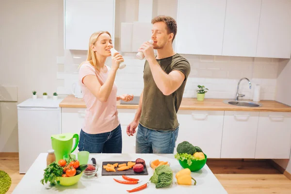 Vegan genç sevgi dolu aile çiğ sebze mutfakta yemek yaparken doğal yüzlü içer. Detoks diyet. Mutlu çift. Çiğ gıda diyet. Vejetaryen yiyecekler — Stok fotoğraf