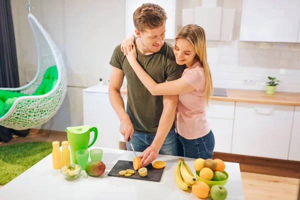 Jovem casal amoroso cozinhar frutas orgânicas para suco na mesa. Comida saudável. Família feliz. Alimentação saudável — Fotografia de Stock