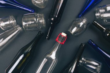 Çevreyi koruyun. Karanlık arka planda boş renkli cam şişeler geri dönüşüm, üst görünüm. Yeniden geri dönüşümü azaltın. Gezegenimizi kurtarın