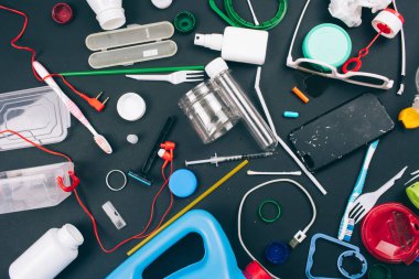 Tek kullanımlık plastik reddetme. Plastik kirlilik kavramı. Koyu arka planda turuncu, yeşil, mavi tek kullanımlık plastik atık. Plastik atıkların azaltılması için yeni kurallar, AB Direktifi. Plastik ücretsiz olun. Üst görünüm.