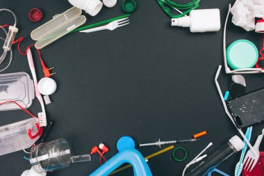 Tek kullanımlık plastik reddetme. Plastik kirlilik kavramı. Koyu arka planda turuncu, yeşil, mavi tek kullanımlık plastik atık. Plastik atıkları azaltmak için kurallar, AB Direktifi. Plastik ücretsiz olun. Kopyaya sahip üst görünüm