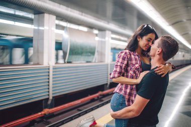 Genç bir adam ve bir kadın yeraltını kullanıyor. Metroda bir çift. Aşk hikayesi. Genç adam kadını ellerinin arasına aldı ve öptü. İlk görüşte aşk. Kentsel modern görünüm.