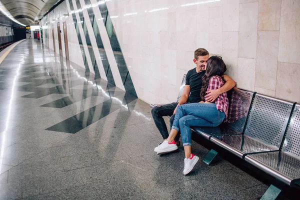 Mladý muž a žena používají podzemí. Pár v metru. Krásný mladý muž a žena sedí spolu. Objal ji a políbil. Láska na první pohled. Zobrazení měst. — Stock fotografie